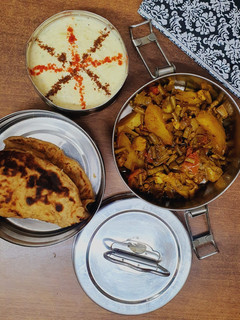 A picture of Paratha with Black-Eyed Peas and Potato Curry and Cucumber Raita.
