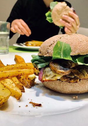 Una foto de Burger Veggie de lentejas, champiñones, cebollita caramelizada, queso y rúcula en pan integral 🍔