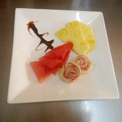 A picture of Swiss roll & fruit cuts.