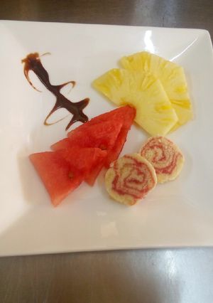 A picture of Swiss roll & fruit cuts.