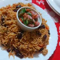A picture of Mexican Beans Rice with salsa.