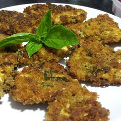 A picture of Breaded chicken with fresh basil.