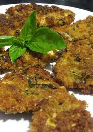 A picture of Breaded chicken with fresh basil.