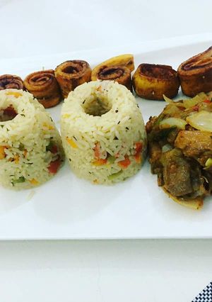 A picture of Coconut rice with fried plantain and beef.