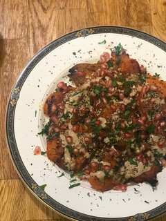 Una foto de Boniatos al horno con tahini, granada y zatar