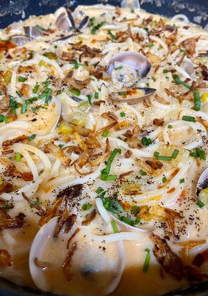 Una foto de Spaghetti caldoso con almejas, coco, piparras y café