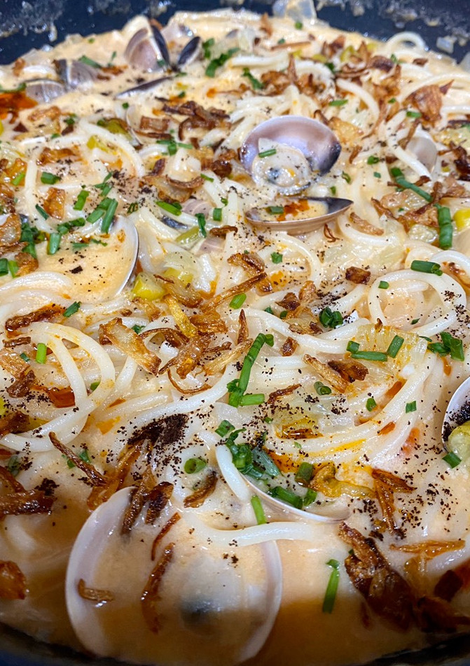 Una foto de Spaghetti caldoso con almejas, coco, piparras y café