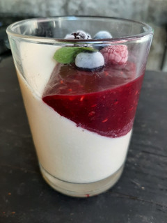 Una foto de Panacotta con salsa de frutos rojos