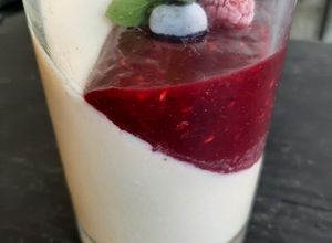 Una foto de Panacotta con salsa de frutos rojos