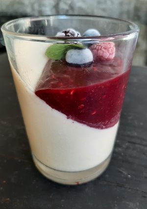 Una foto de Panacotta con salsa de frutos rojos