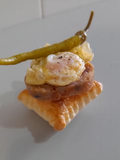 Una foto de Pincho de pies de cerdo, huevo de codorniz y piparra