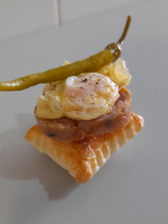 Una foto de Pincho de pies de cerdo, huevo de codorniz y piparra