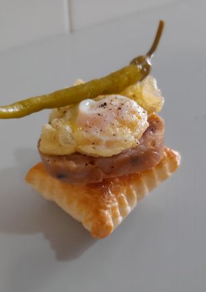 Una foto de Pincho de pies de cerdo, huevo de codorniz y piparra