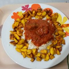 A picture of Ofada Rice with fried plantain and beef.