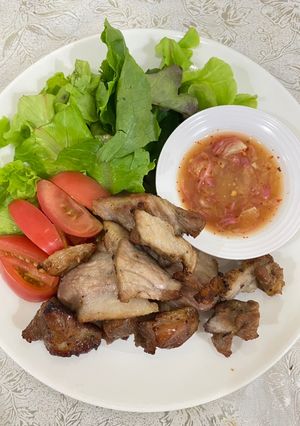 A picture of Roasted garlic marinated pork collar with spicy Thai-style sauce.