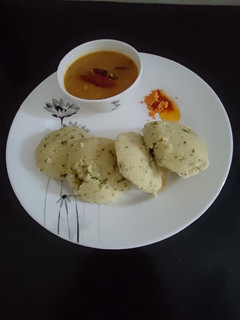A picture of Rava Idli with Sambar and podi.