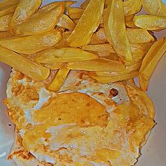 A picture of Air fryer chips with fried eggs.
