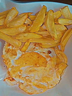 A picture of Air fryer chips with fried eggs.