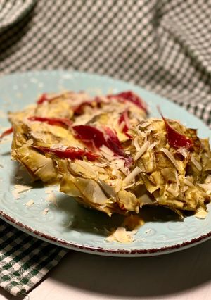 Una foto de Flores de alcachofa con salsa cremosa, ibérico y lascas de parmesano