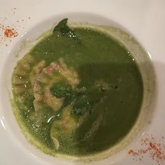 A picture of Watercress soup with soft cheese ravioli.