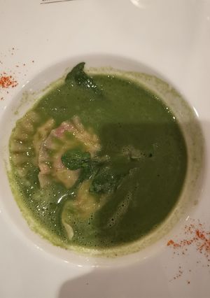 A picture of Watercress soup with soft cheese ravioli.