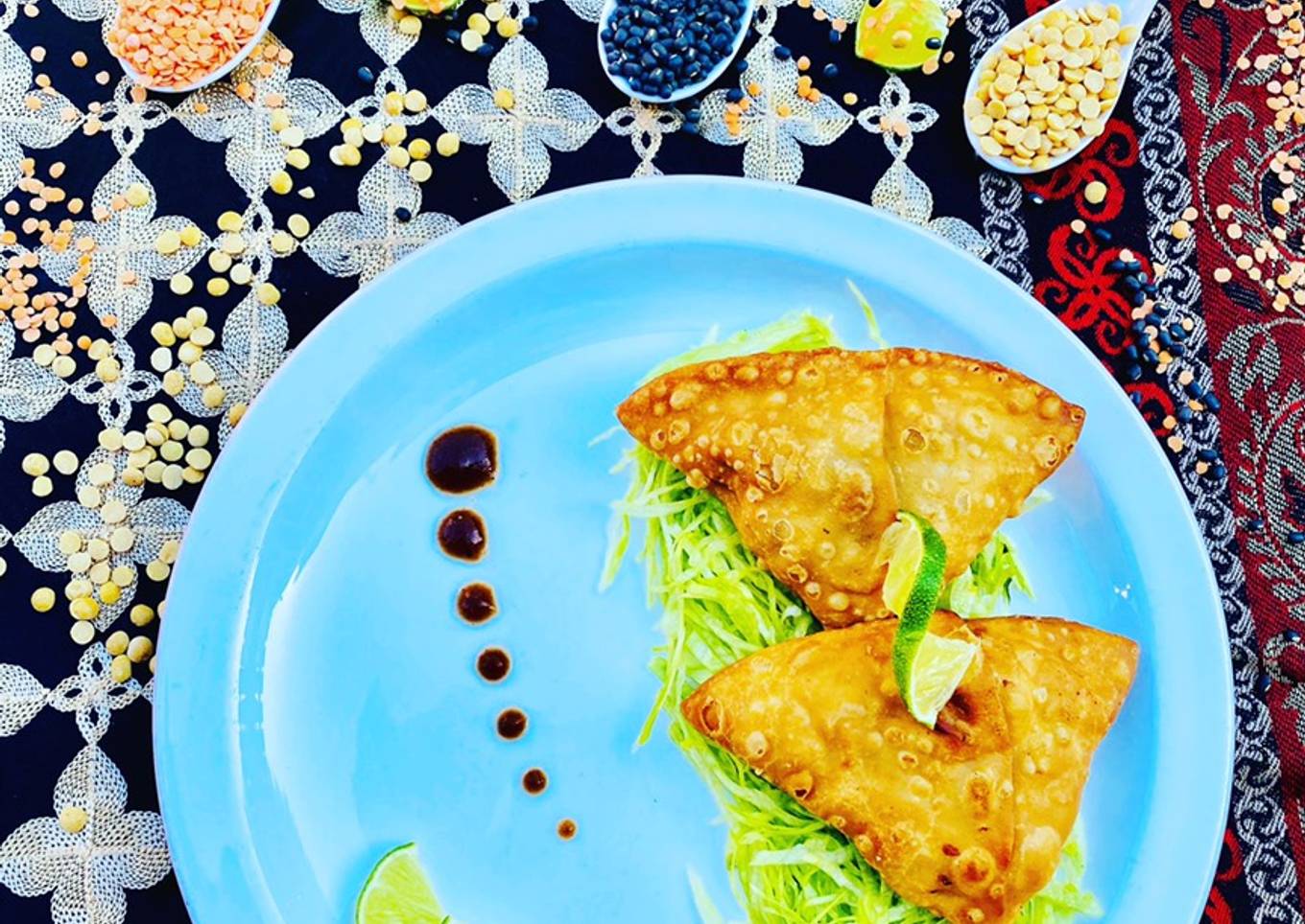 Homemade Fresh Samosa served on bed of lettuce with tamarind sauce and limes
