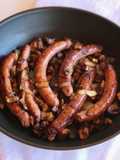 Salsitxes amb vi negre, ceba i pastanaga