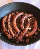 Salsitxes amb vi negre, ceba i pastanaga
