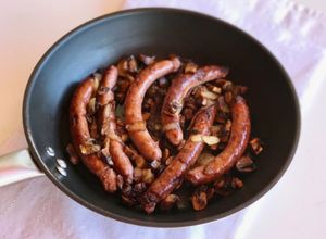 Foto principal de Salsitxes amb vi negre, ceba i pastanaga