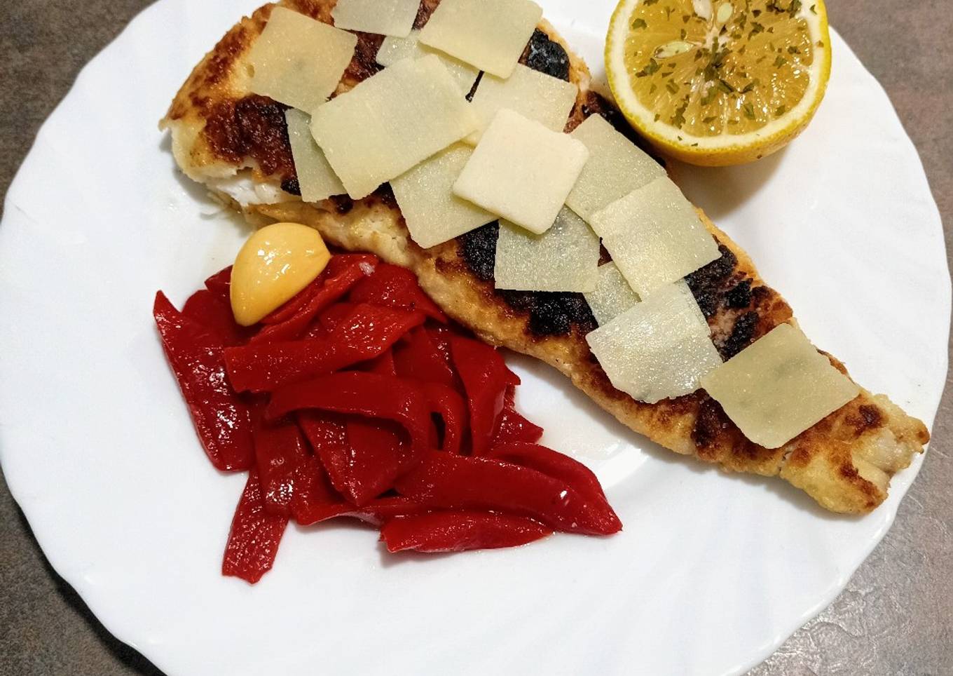 Filete de merluza con pimientos del piquillo y grana padano
