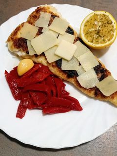 Una foto de Filete de merluza con pimientos del piquillo y grana padano