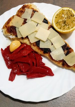 Una foto de Filete de merluza con pimientos del piquillo y grana padano