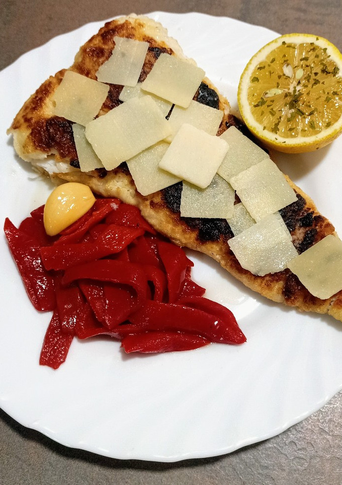 Una foto de Filete de merluza con pimientos del piquillo y grana padano