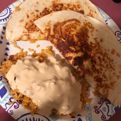 A picture of Nacho quesadillas and queso covered Spanish rice.