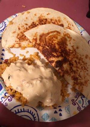 A picture of Nacho quesadillas and queso covered Spanish rice.