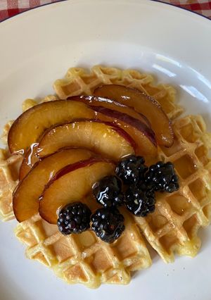 A picture of Waffles with fruit and honey.