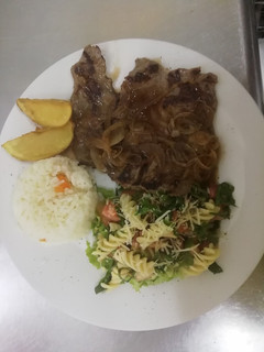 Una foto de Carne encebollada con ensalada de fusilli