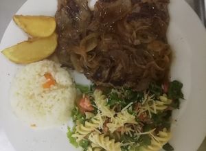 Una foto de Carne encebollada con ensalada de fusilli
