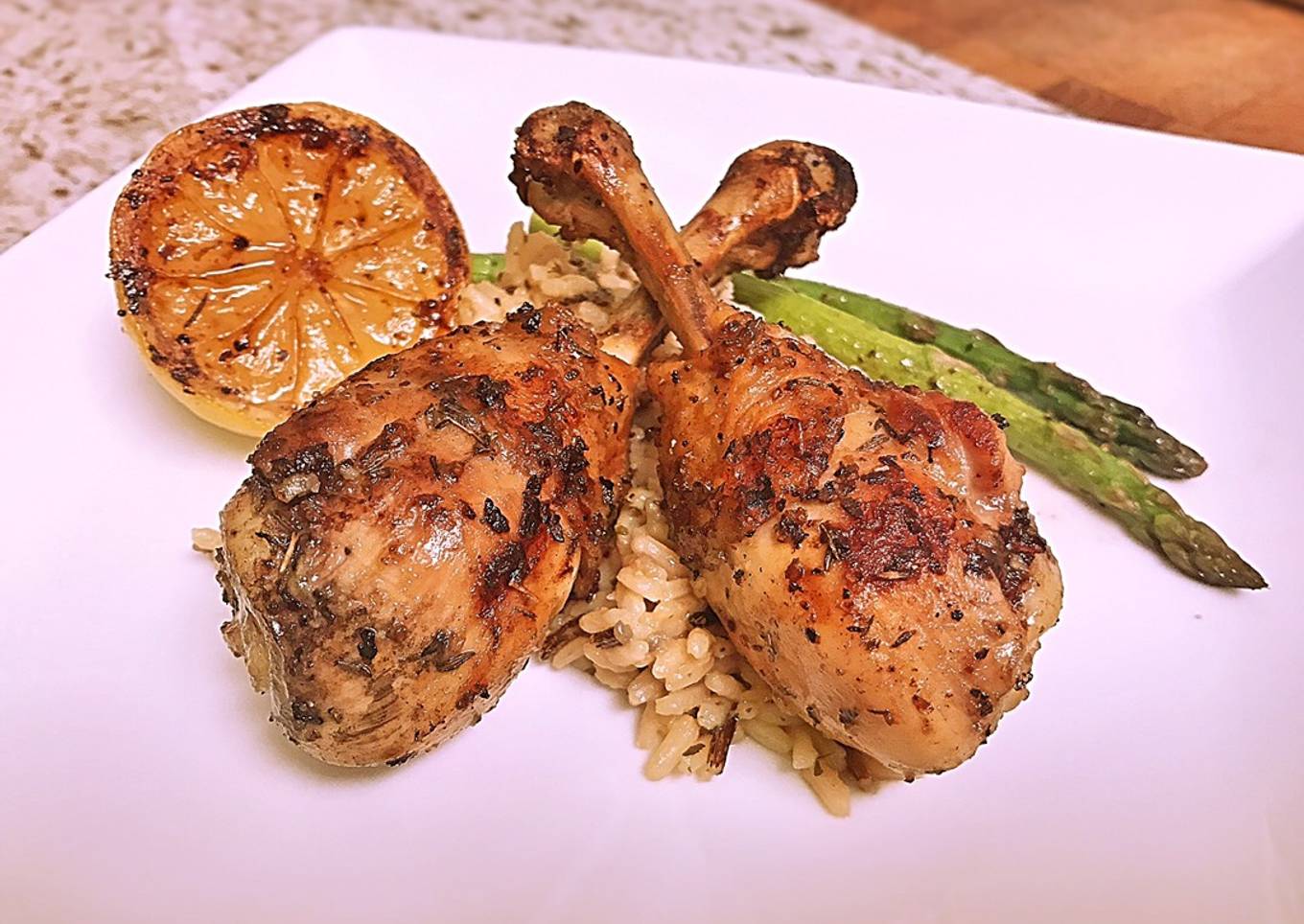 French cut grilled lemon pepper drums with wild rice and asparagus