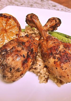 A picture of French cut grilled lemon pepper drums with wild rice and asparagus.