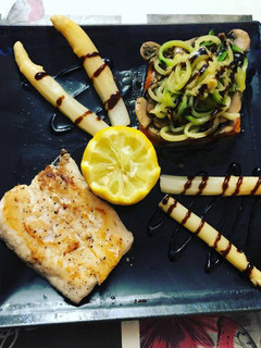 Una foto de Merluza a la plancha con rombo de coliflor, pimientos, champiñones, calabacín y espárragos