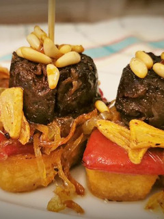 Una foto de Pincho de Morcilla con Piquillos, Cebolla caramelizada y Piñones