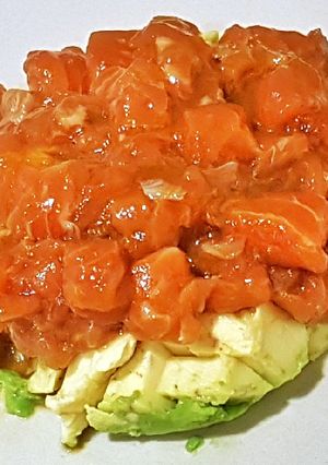 Una foto de Tartar de Salmón marinado con vinagreta de Mango sobre Aguacate