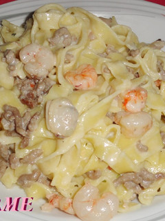 Una foto de Fetuccini con carne y marisco