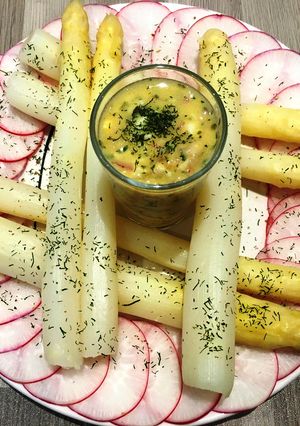 Une photo de Asperges sur lit de pétales de Radis et sauce Gribiche