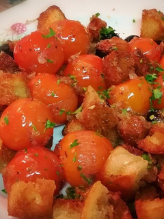 Una foto de Ensalada templada de cherrys con pan frito y aceitunas negras