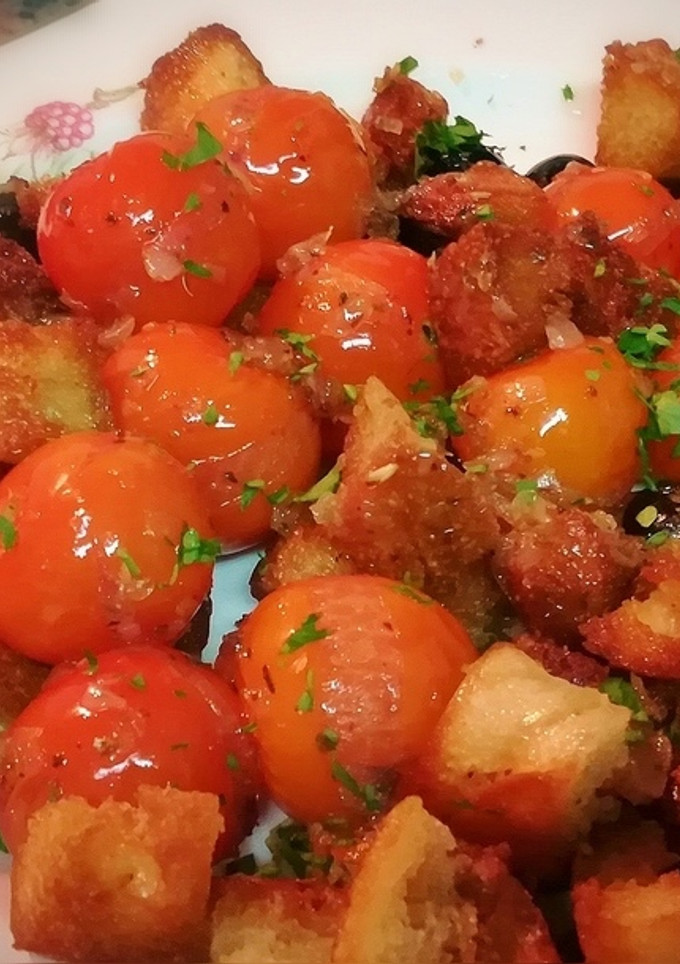 Una foto de Ensalada templada de cherrys con pan frito y aceitunas negras
