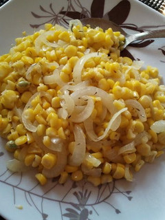 A picture of sauteed corn and white onion.