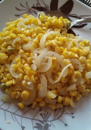 A picture of sauteed corn and white onion.