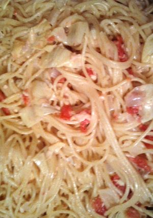 A picture of spaghetti with artichoke hearts and tomatoes.